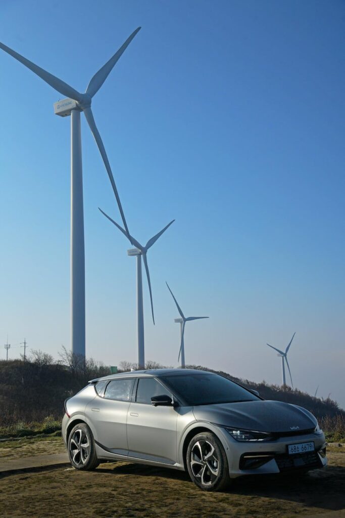 car parked near wind turbines under blue sky